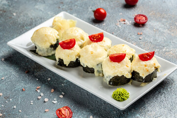 Closeup on served baked sushi rolls. Japanese traditional baked roll with fish and sauce, Restaurant menu, dieting, cookbook recipe top view