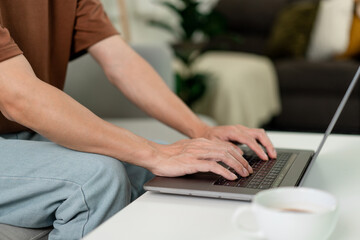 Technology Concept The man in brown T-shirt concentrating on typing something on his computer laptop