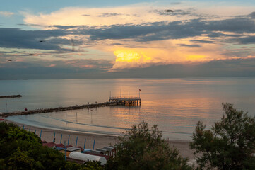 Lido Di Venezia. Spiaggia dei Murazzi con molo e nubi al tramonto