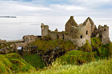 Ruins of Dunluce Castle, Antrim, Northern Ireland during sunny day with semi cloudy sky. Irish ancient castle near Wild Atlantic Way.