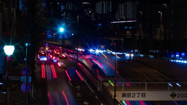 A night timelapse of the traffic jam at the city street in Tokyo long shot panning