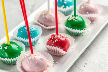 Brightly colored cake pops on a white plate, catering banner, menu, recipe