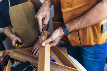 Father is teaching his son of working with wood at home. Close up