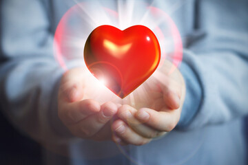 Hands holding red heart, The concept of love, friendship and peace. The concept of health, the fight against coronavirus, the fight against heart problems. organ donation