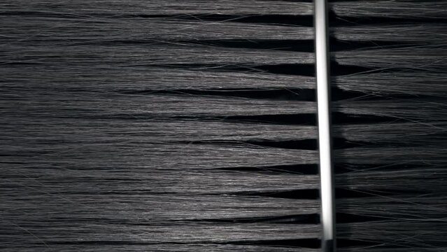 Vertical shot of Silver comb combing black hair | Hair loss treatment concept