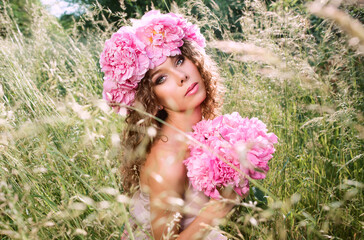 caucasian beautiful woman with a wreath of pink peonies on her head. Spring, blossom, fairy concept