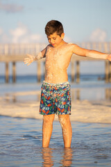 Fototapeta na wymiar Little kid covered in sand on the beach