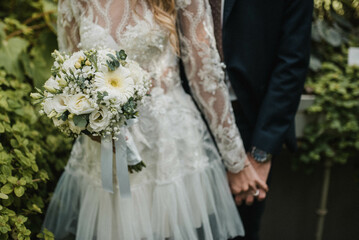 Newlywed romantic wedding couple walking. The bride and groom walk holding hands.