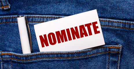 The back pocket of blue jeans contains a white pen and a white card with the text NOMINATE