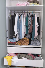 Messy clothes thrown on a shelf. dressing room mess, decluttering concept.