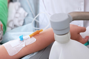 Obraz premium Administration of drugs intravenously. A child's hand. Preparation for the operation. Close-up of a child's hand.Modern medicine. Saving a life.