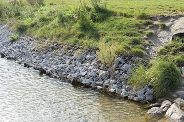 Strengthening the banks of the river, mesh and stones