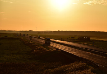 Trucks with Semi-trailer driving on highway on sunset. Goods Delivery. Services and Transport logistics. Lorry driven on highway. Traffic on road. Semi truck in motion drive. Semi-trailer truck..