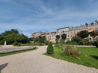 Obraz premium Foto von Schritten auf der Straße. Blick entlang der Stadtstraße. Ein Spaziergang entlang des gepflasterten Weges im Dorf. Asphaltstraßen mit Fußgängerwegen. Verzweigte, von Bäumen gesäumte Allee.