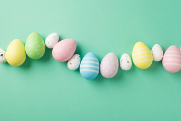 Top view photo of easter decorations row of multicolored easter eggs on isolated teal background with copyspace