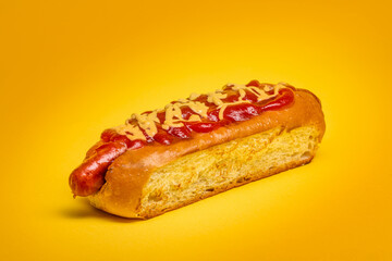 Hot-dog with Sausage and Sauce on a yellow background. Fried Sausage with Ketchup and Mustard