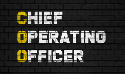 Chief operating officer (COO) concept,business abbreviations on black wall 