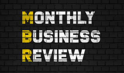 Monthly business review (MBR) concept,business abbreviations on black wall 
