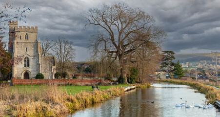 View of the restored Stroudwater Canal as it passes the Church of St Cyr near Stroud Gloucestershire, United Kingdom