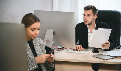 Young attractive woman and adult man are working in the office. Open space concept for teamwork