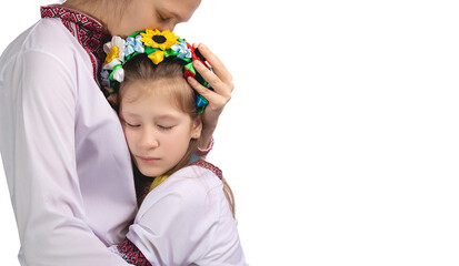 The mother hugs the child with tearful eyes. A child in Ukrainian national clothes.