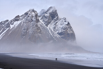 Stokksnes black sand beach and Mt Vestrahorn in winter. People on beach. Southeast Iceland.