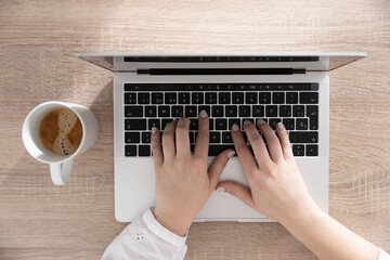 View from above of female hands typing on laptop. Copy writing and online business concept