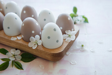 Easter eggs in wooden tray on pink tile background