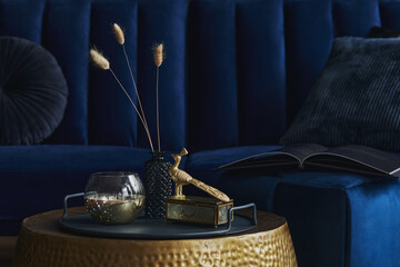 Stylish close up on the elegant details in the glamour living room interior. Golden peacock and...