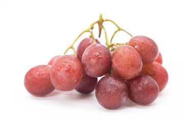 Bunch of red grapes with water drops. Isolated on white background.