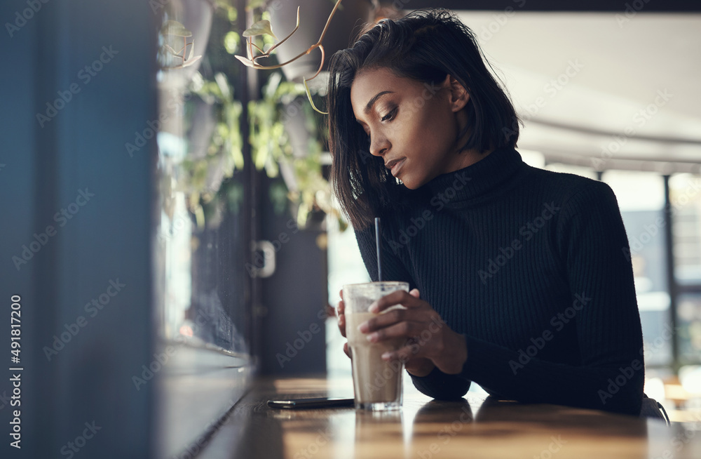 Sticker Never keep a good woman waiting. Shot of a beautiful young woman drinking a iced coffee in a cafe.