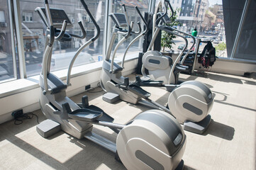 Different fitness training exercise equipment in modern gym interior