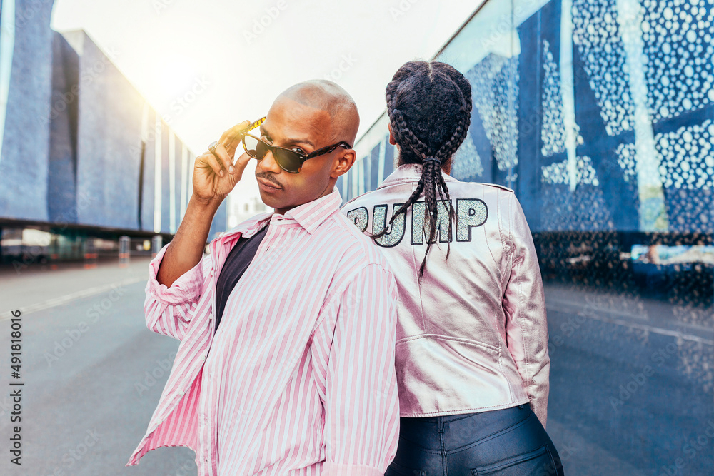 Wall mural outdoor portrait of young mixed race couple posing. stylish couple leaning together at sunset. lifes