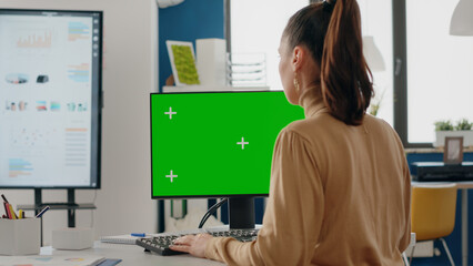 Close up of person using green screen on computer in business office. Woman working with mock up isolated template and blank background on desk. Adult with mock-up app on display