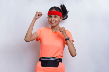 young sporty asian beautiful woman showing strong gesture on white background