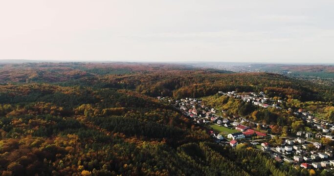 Aerial panoramic view of Reda town in Poland, little traditional mountains village in remote rural countryside with warm sunshine over a conifer pine tree woodland 