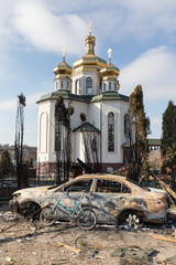 Damaged church and burned car on the outskirts of Irpin