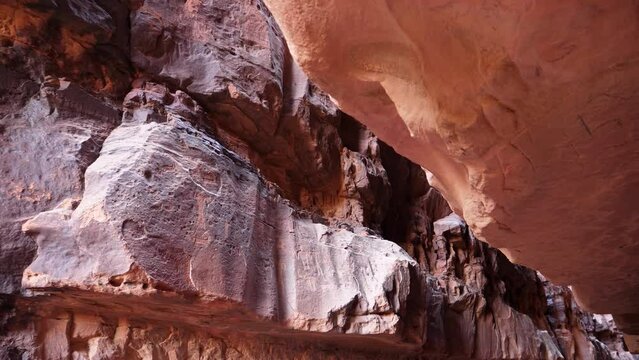 Interior of a red granite cave in the desert with inscriptions and rock drawings created by primitive humans thousands of years ago in Wadi Rum Valley of the Moon Jordan