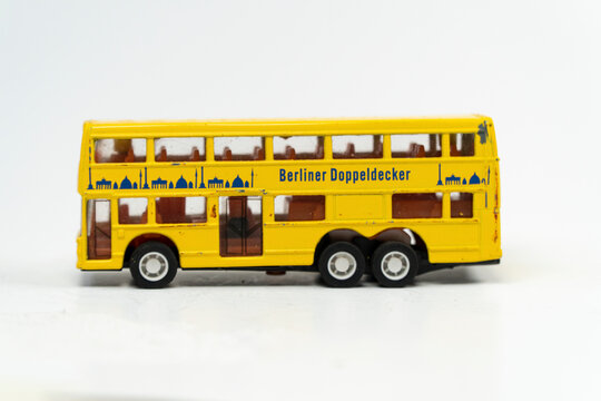 Mini yellow double decker metal bus isolated on white background, big tourist bus mini toy