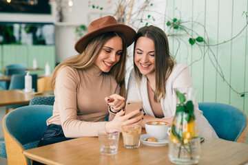women friends drinking coffee in cafe