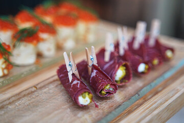 meat snacks in the form of a meat roll with stuffing inside and a small wooden clothespin