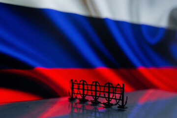 Barbed wire on the background of the Russian flag. The concept of imposing sanctions against Russia