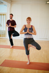 Fototapeta na wymiar Enjoying their yoga session at the gym. Shot of two people doing yoga together in a studio.