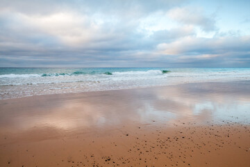 Coastal landscape with wet sand and shore water