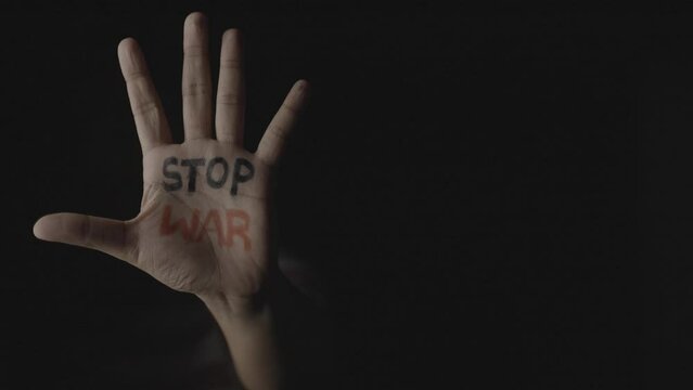 High ISO shot of hand with stop war written showing with copy space in dark background - concept of independence and freedom