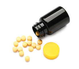 Bottle with yellow pills on white background