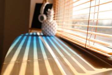 Wooden surfboard on window sill in room