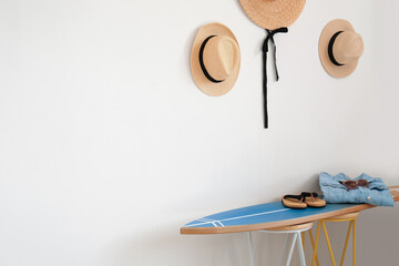 Interior of modern stylish room with surfboard, hats and female accessories