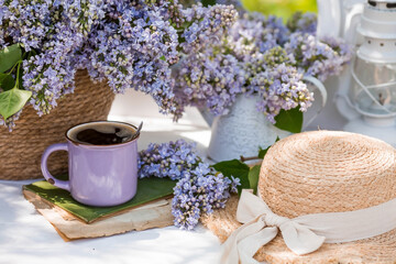 The postcard is beautiful. A fancy purple coffee mug, an old book, a straw hat and a bouquet of...