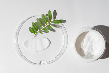 White cosmetic cream strokes on white background. Skincare lotion face serum smear. Beauty product texture. White jar of face or body cream. Top view, hard shadows.